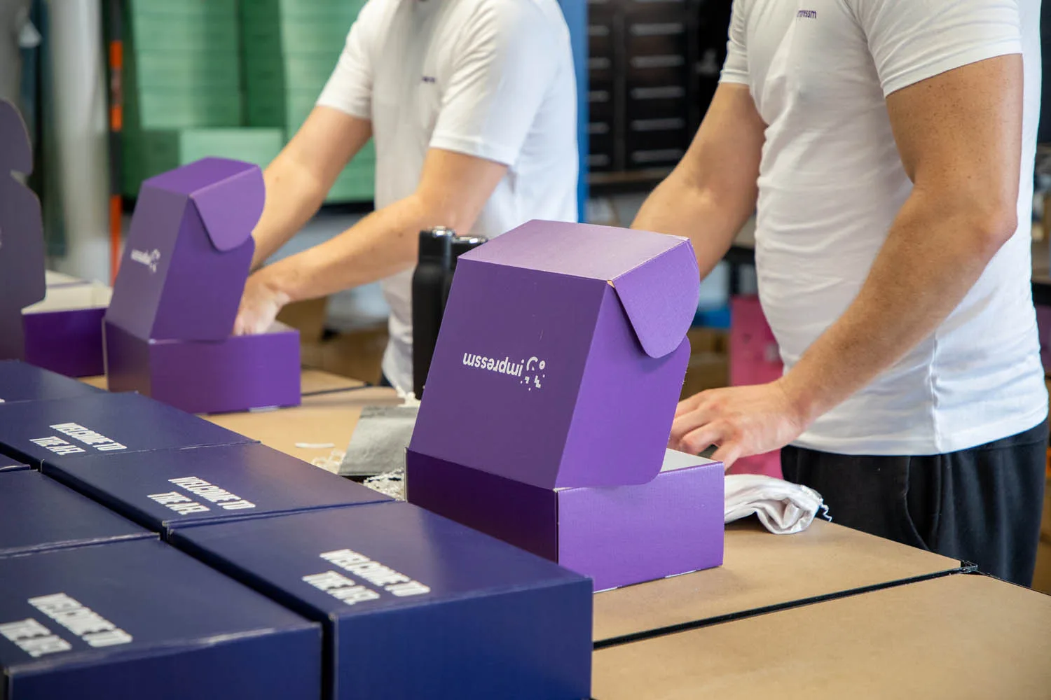 The Impressm team packing branded welcome boxes