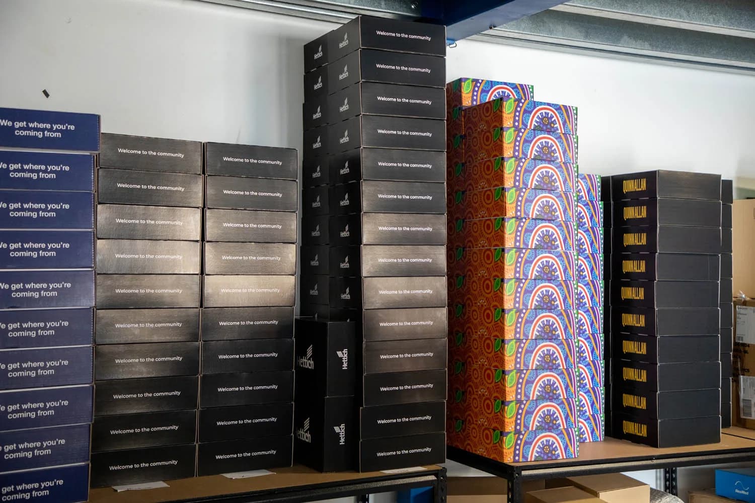 Stacked customer welcome packs on the shelves in the Impressm warehouse