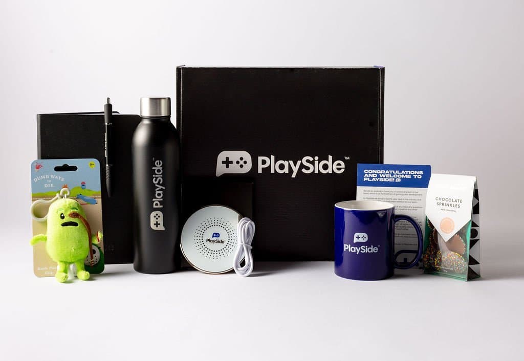 A PlaySide-branded welcome box with bottle, mug, notebook and a welcome card